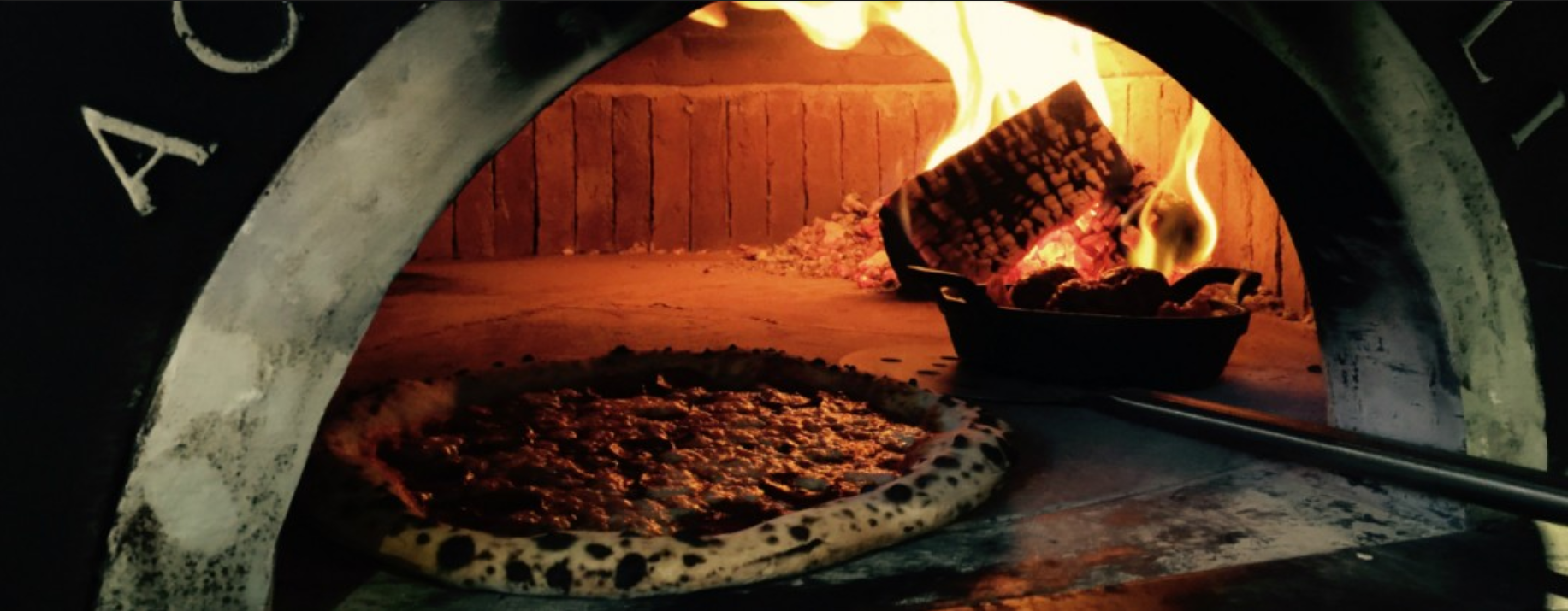 pizza getting cooked in coal